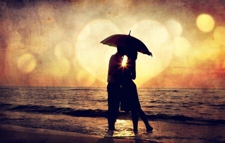 17347546 - couple kissing under umbrella at the beach in sunset. photo in old image style.