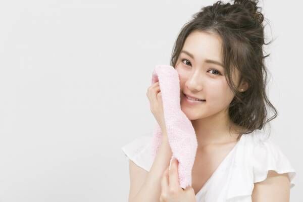 タオルで顔を拭く女性