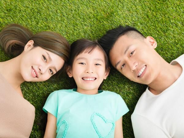 top view of Happy Young Family lying on the grass
