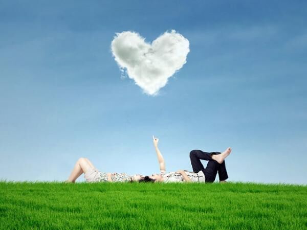 Couple enjoy holiday under heart cloud in park