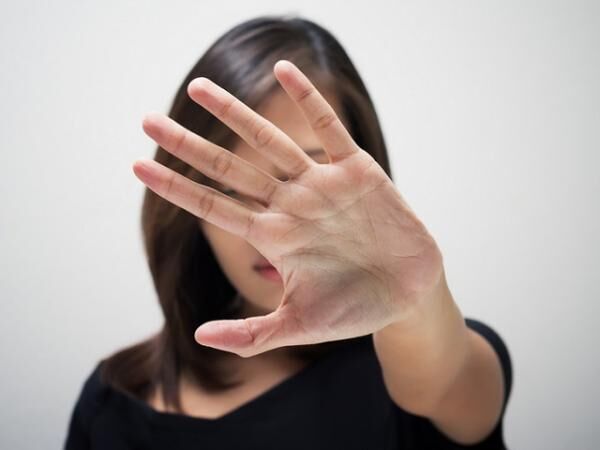 A woman holding her hand straight out in front of her face