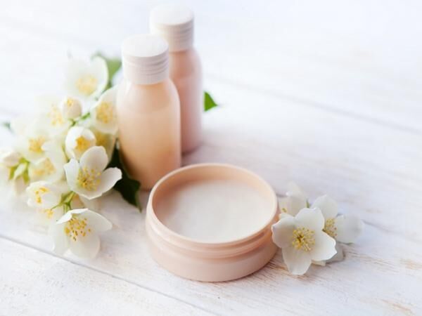 Spa setting with beauty cream and white jasmine flower