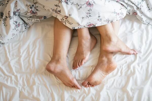 ベッドから出ているカップルの足