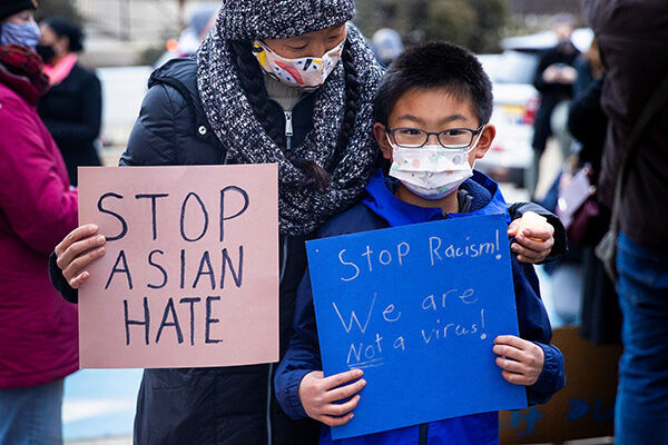 デモで「私たちはウイルスじゃない」と訴えるアジア系親子（写真：ロイター／アフロ）