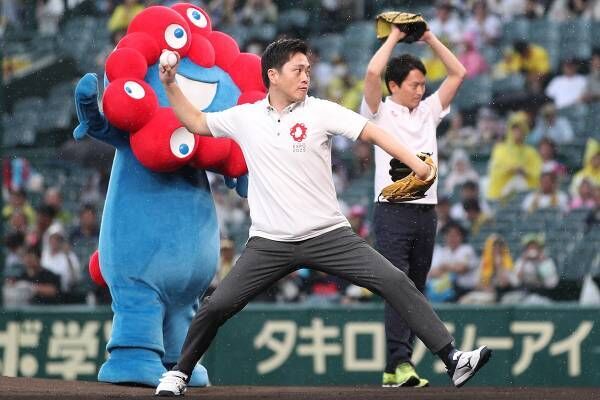 不気味と話題の「ミャクミャク」とともに、甲子園で始球式を務める吉村知事（写真：時事通信）