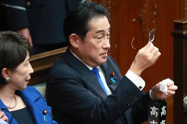 “増税メガネ（？）”をチェックする岸田首相（写真：時事通信）