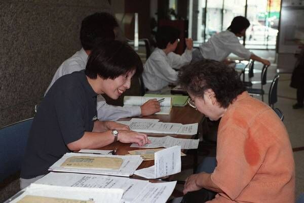 介護保険の申請で行政窓口を訪れた市民（右・写真：時事通信）