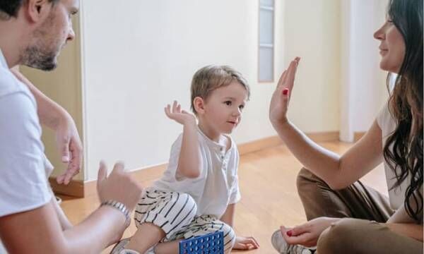 母親とハイタッチをしようとしている2歳くらいの息子