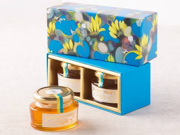 「ウクライナ産ひまわりはちみつ」がアートパッケージで登場。ウクライナ養蜂の復興を願い、現代美術アーティスト荻野夕奈の描くひまわり畑をデザイン【クインビーガーデン】