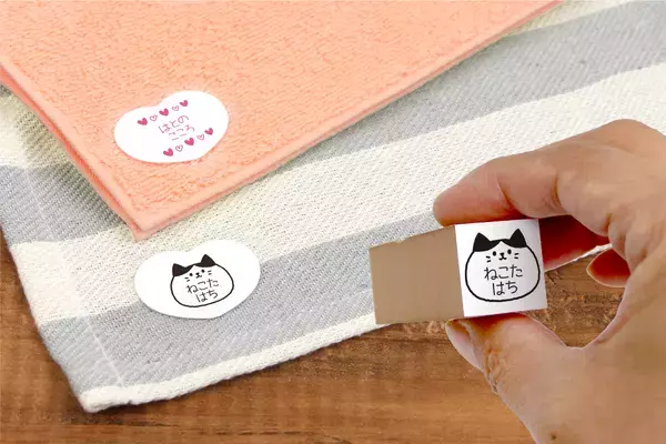 《SDGs商品》ご好評のため“猫・くま・ハート”のカタチを追加！2年かけて開発した素材から誕生の名前スタンプが押せる布用シールです。（布に指で貼ることができる「布ハレちゃん。のキレハシ」使用）