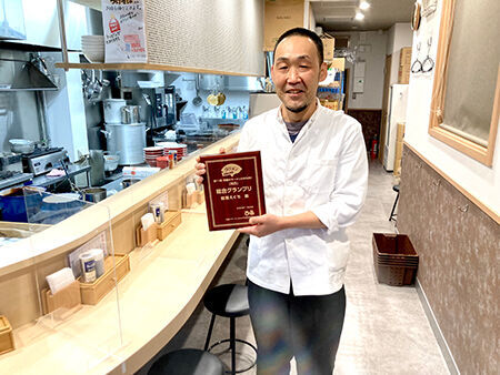 総合グランプリの盾を手渡され、受賞の喜びをかみしめる「麺屋えぐち」店主の江口さん。