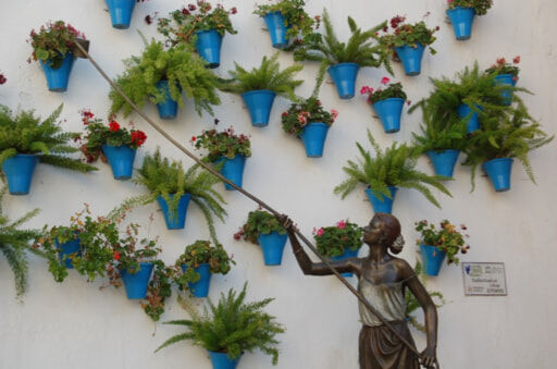 壁の鉢植えに水やりをする方法（コルドバの街にある彫刻）