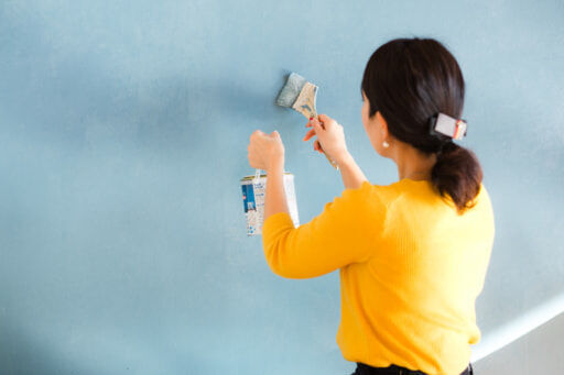 壁の塗装をする香村さん