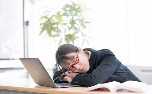 パソコン作業中に寝てしまう女性のイメージ