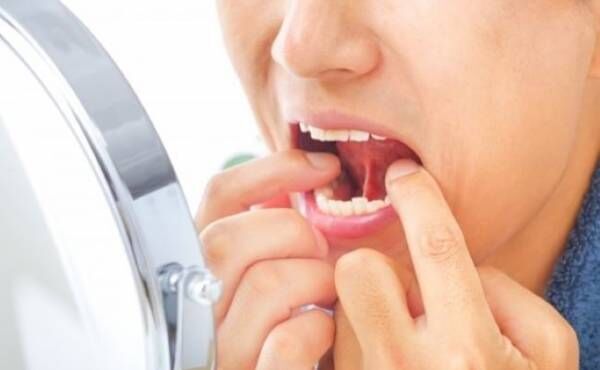 鏡で歯を確認する女性