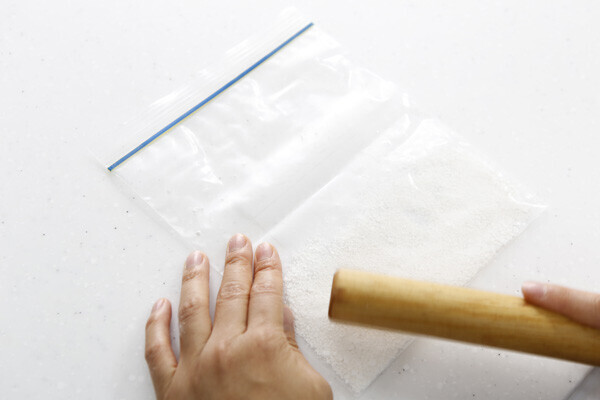 白玉粉のかたまりを袋に入れ、麺棒で袋の上から叩いて粉にします