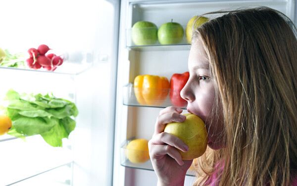 冷蔵庫を開けて、野菜を食べる女の子