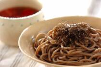 2025年9月12日(金)の献立は「ツナトマ冷やしそば」の献立。麺料理で不足しがちな野菜を、つけだれに入れて。餃子の皮を野菜にすることでビタミン補給に。