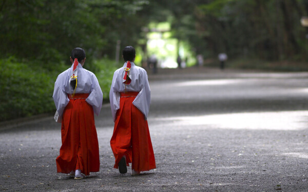 神社の境内を歩く二人の巫女