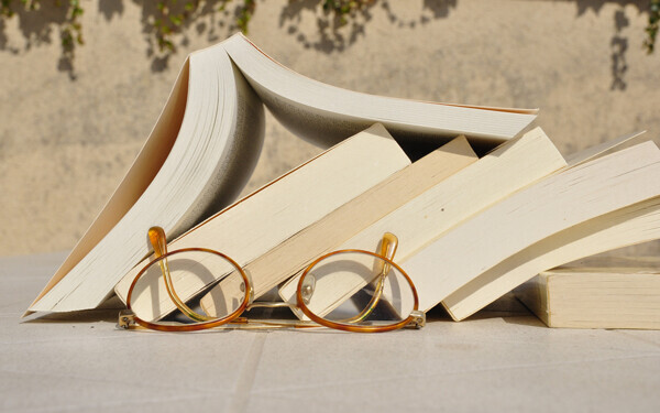 積み重なった本とメガネ