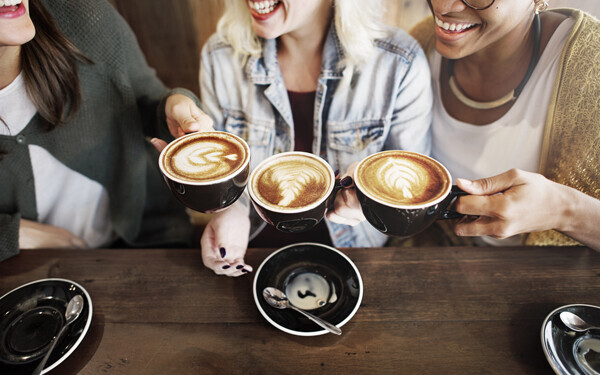 コーヒーを飲みながら談笑している3人の女性たち