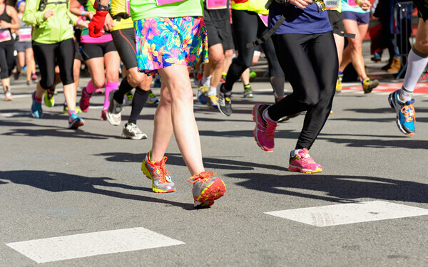 マラソン大会で歩道を走る女性ランナーたち