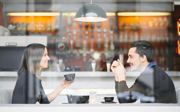 コーヒーを飲みながら会話をする男女のカップル