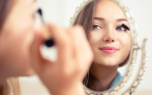 鏡を見ながら化粧をする女性