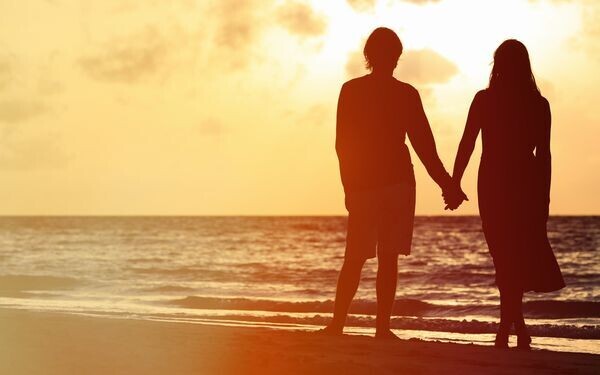 浜辺で手をつなぐカップル