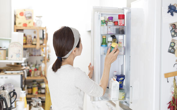 キッチンで冷蔵庫をあける女性