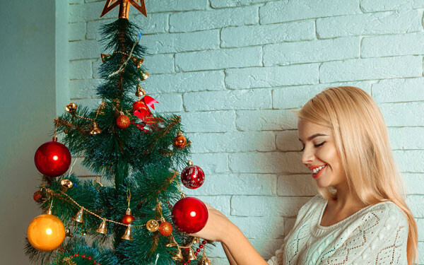 クリスマスツリーを飾りつける女性