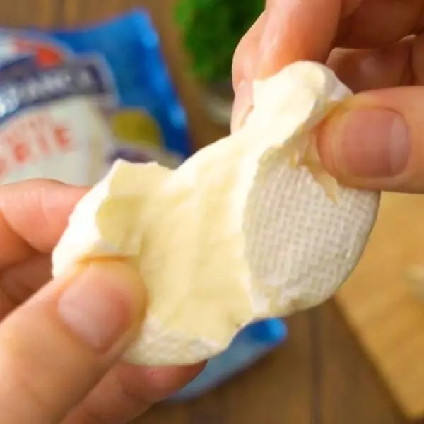 コストコのミニブリーチーズを手でちぎっている写真