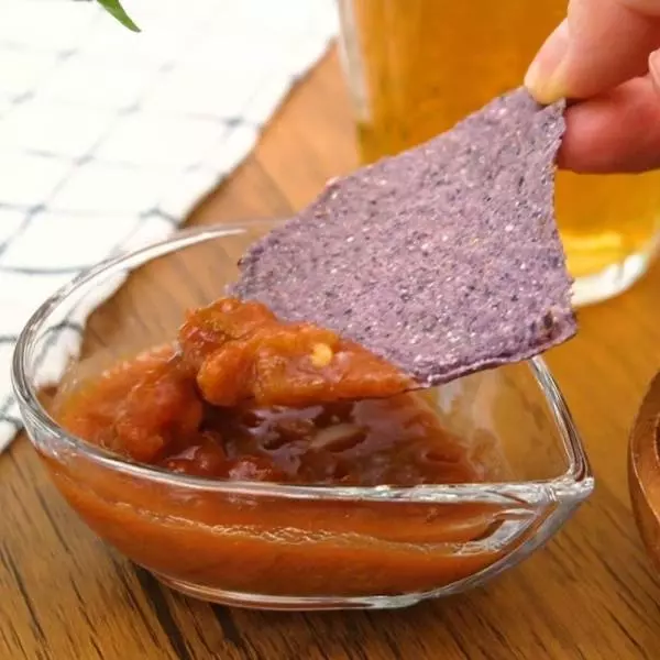 コストコのブルーコーントルティーヤチップスにサルサソースをつけている写真