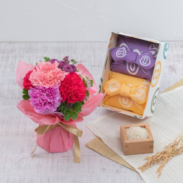 ～母の日ギフトや内祝いのお返しに、はなやぎを。～八代目儀兵衛と初コラボレーション、「お米と花のギフトセット」を日比谷花壇がデザイン。3月1日（水）から、八代目儀兵衛オンラインショッピングサイトで発売されます。日比谷花壇オンラインショッピングサイトでも、母の日限定のそのまま飾れるブーケセットを注文受付開始。