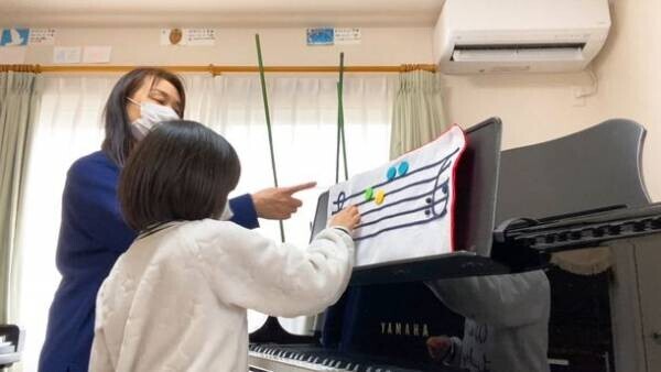 小さいお子さんが楽な姿勢で演奏できる、セミオーダーのグランドピアノ用補助譜面台が販売開始